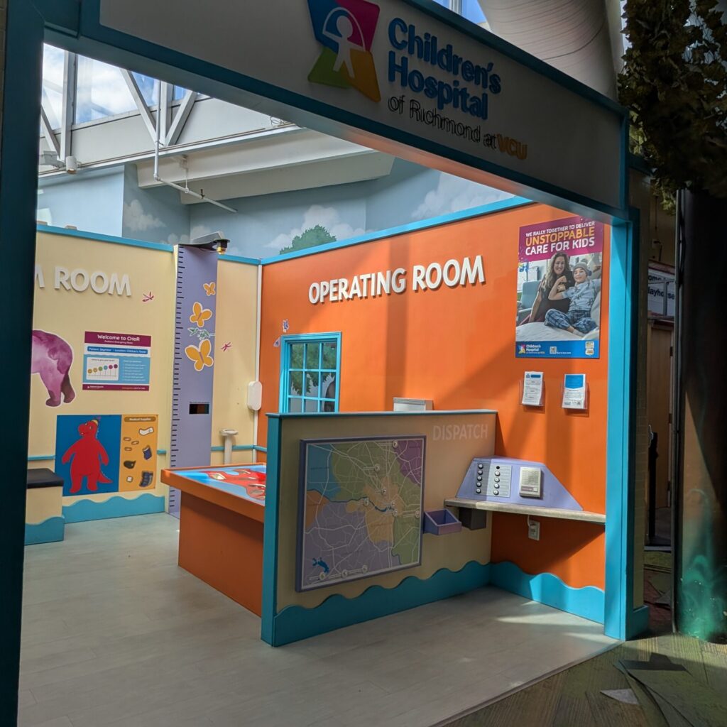 Children's Hospital of Richmond at VCU play exhibit featuring an operating room, dispatch desk, and colorful wall art.