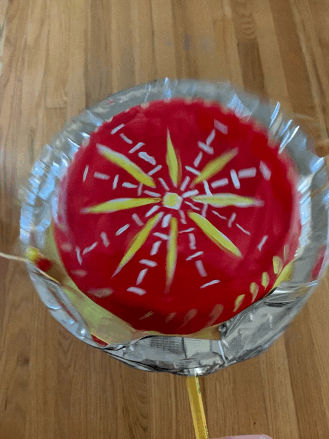 Red Lunar New Year drum balloon with yellow and white accents. Festive holiday decoration.