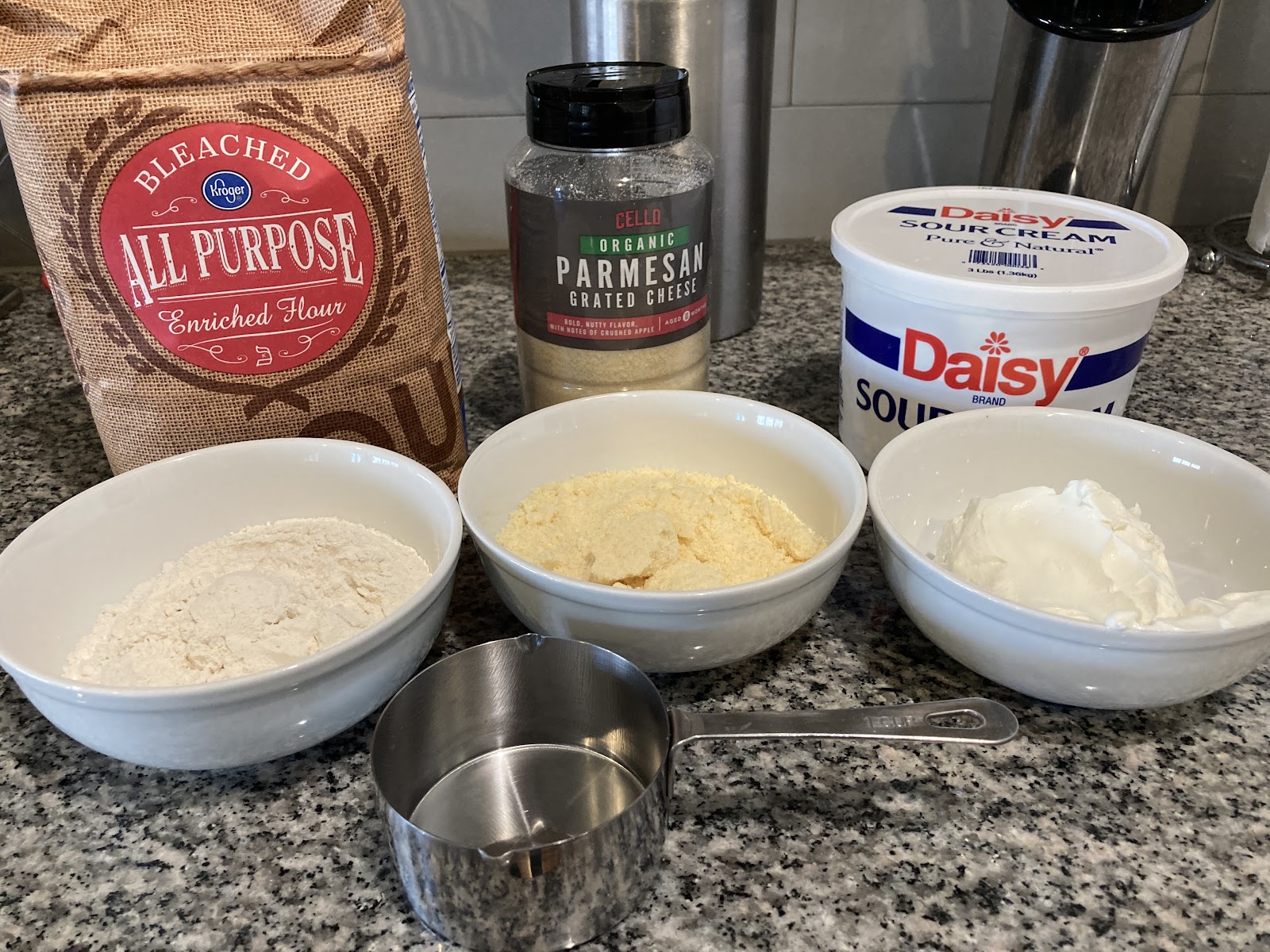 Cooking ingredients: flour, parmesan, sour cream, and measuring cup. Cooking together in Spanish.