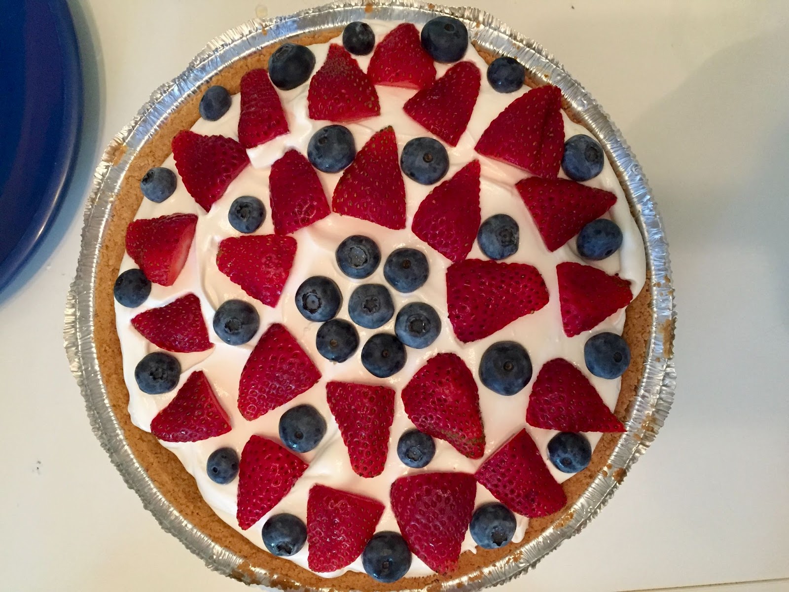 4th of July Pie. Patriotic dessert with strawberries, blueberries, and whipped cream. Red, white, and blue pie.