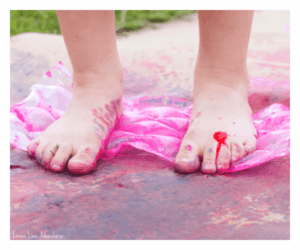 Child's feet stomping bubbles filled with paint. Outdoor bubble stomping activity. Fun downtown activity.