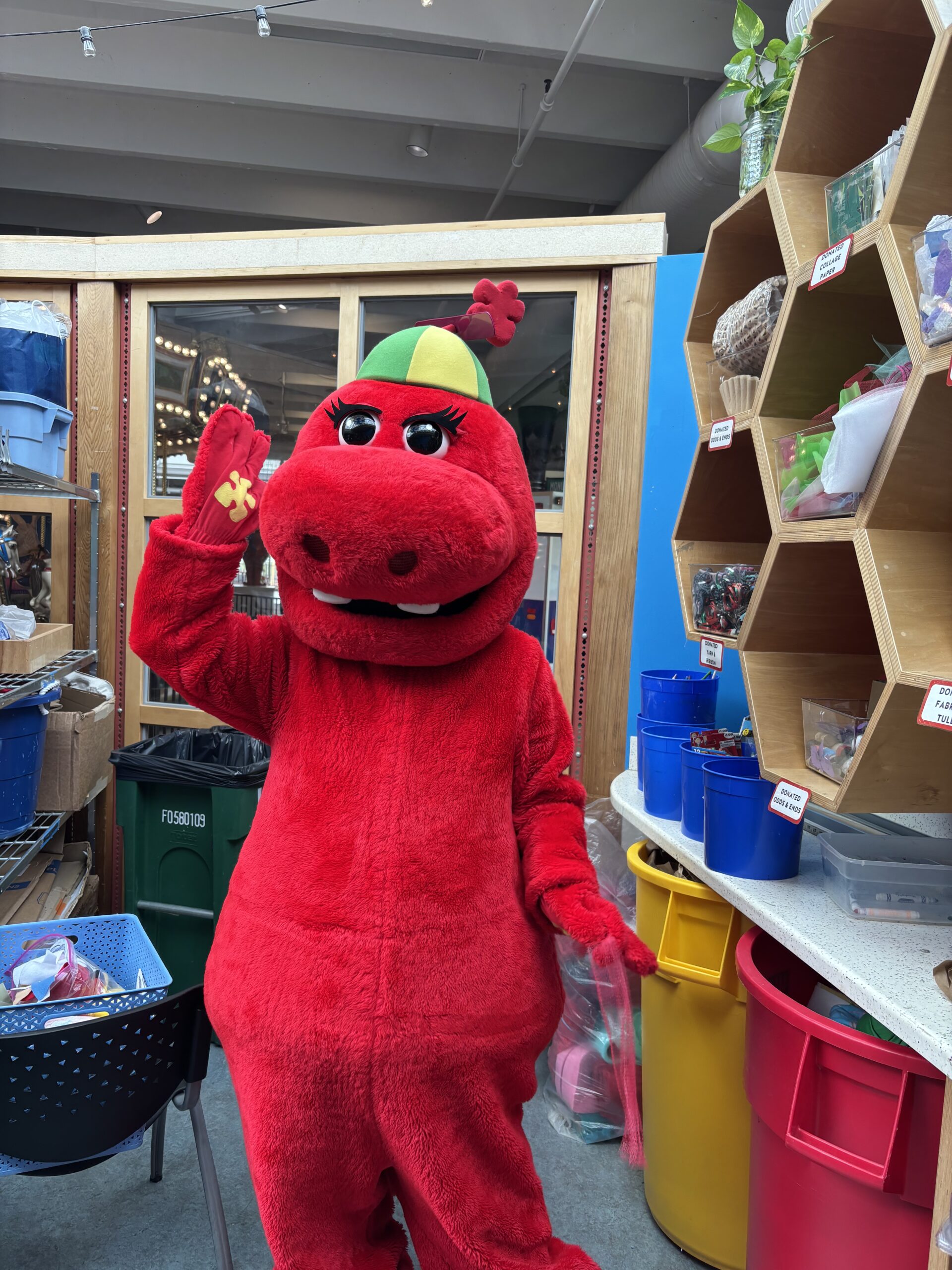 Red mascot at the Art Creation Station downtown. Fun character for kids' art activities.