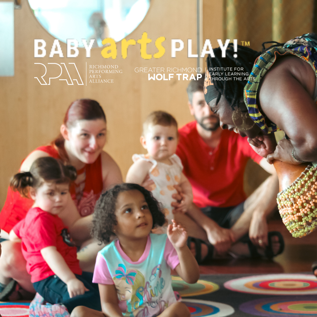 Performer plays a beaded gourd instrument for a group of toddlers and parents during a Baby Artsplay! session.
