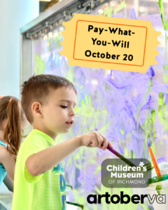 Child paints with a brush on a glass wall at the Children's Museum of Richmond for an artoberVA event.