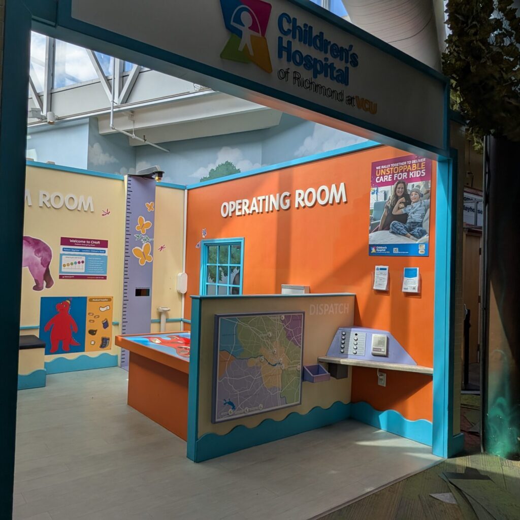 Children's Hospital of Richmond at VCU play exhibit featuring an operating room, dispatch desk, and colorful wall art.