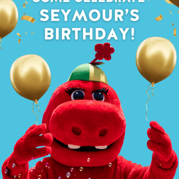 Seymour's 20th Birthday Celebration! Red mascot with balloons and confetti on a blue background.