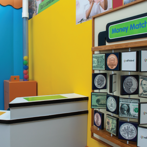 Bank exhibit featuring a money matching game with coins and bills, plus a colorful ball display.